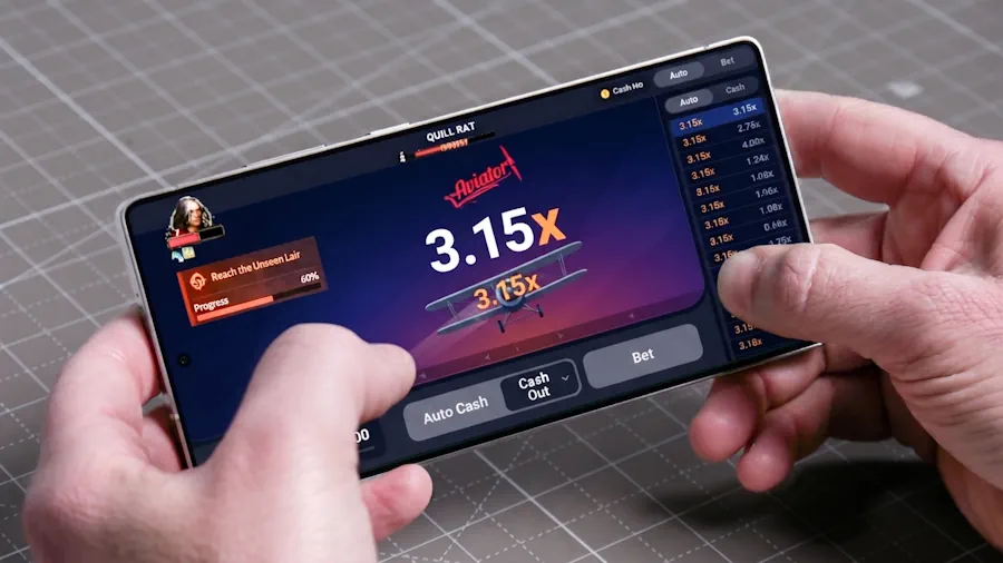 Player holding a smartphone running a mobile crash game with a live multiplier interface